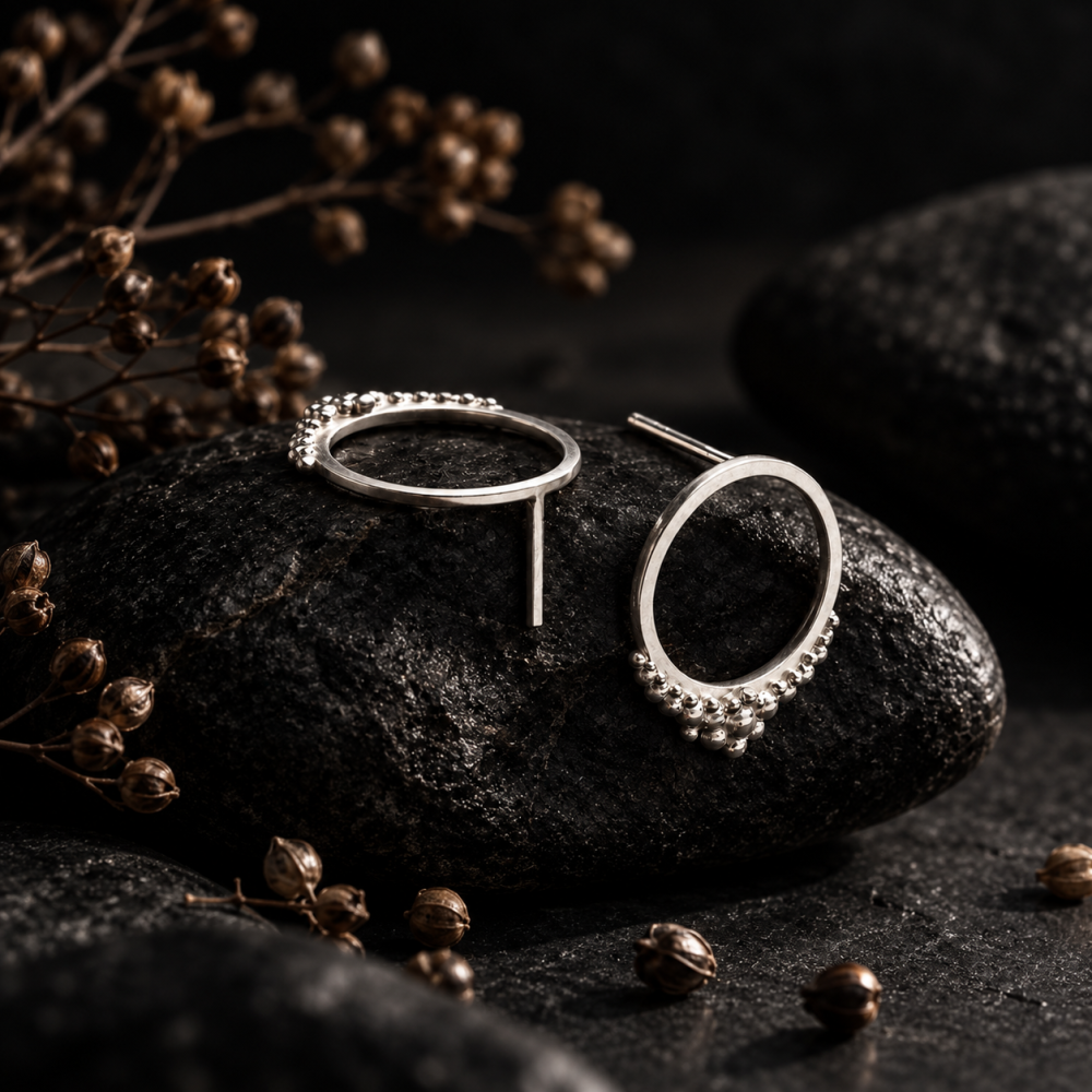 Puces d'oreilles rondes artisanales avec granulation. Mise en scène générée par l'IA, le bijou est réel et fait main.