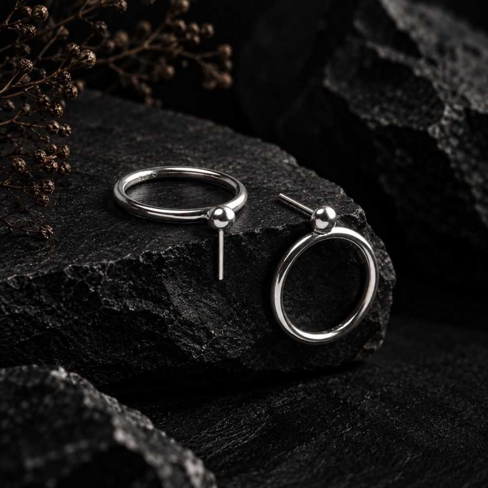 Puces d'oreilles rondes en argent 925 de style minimalistes faites mains. Mise en scène générée par l'IA, le bijou est réel.