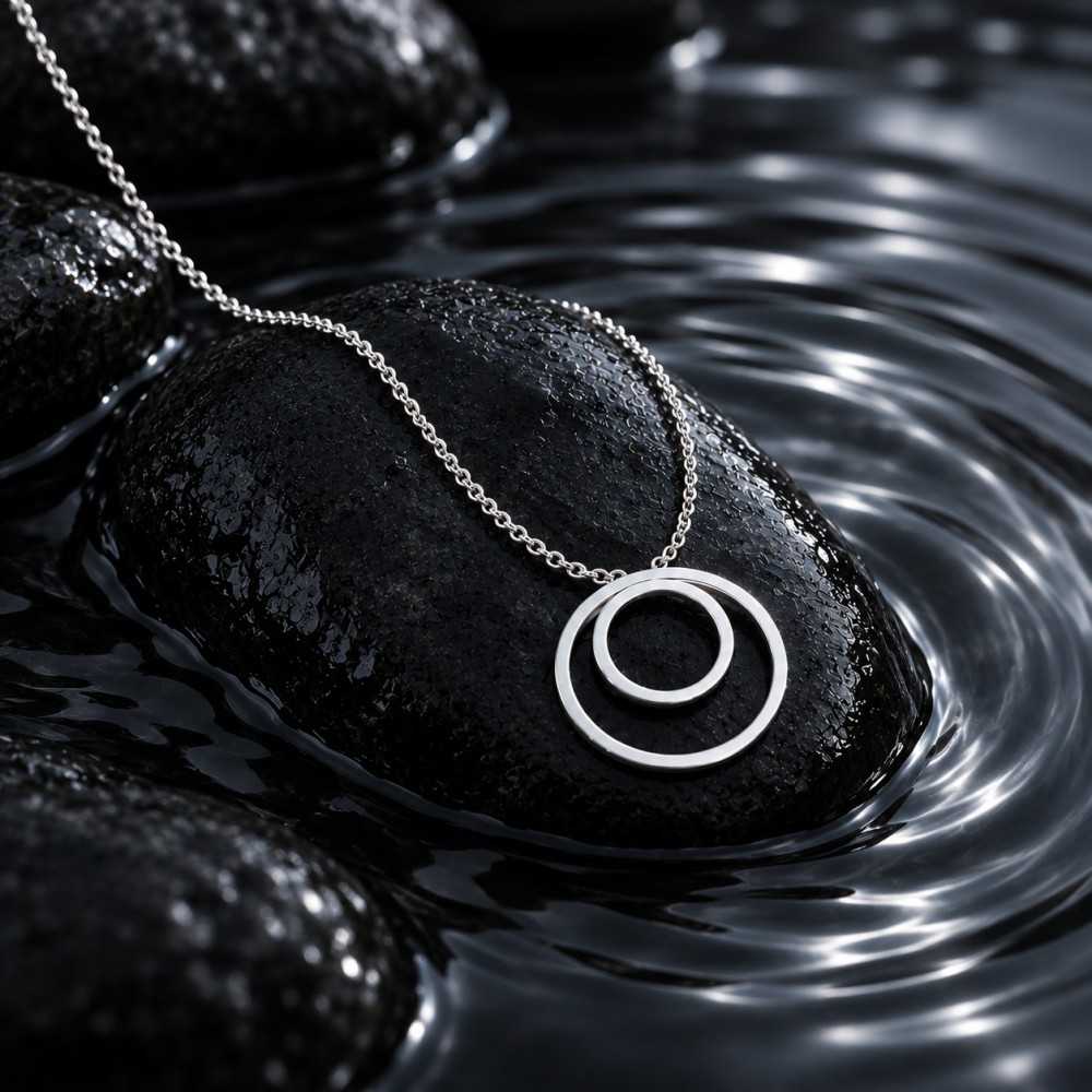 Bijou inspiré des ondes d'eau. Collier réalisé à la main à Yverdon en Suisse. Mise en scène générée par l'IA. Le bijou est réél.