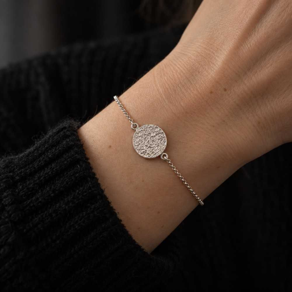 Bracelet médaillon rond texturé en argent 925 pour femme. Photo portée. Bracelet artisanal suisse à offrir.