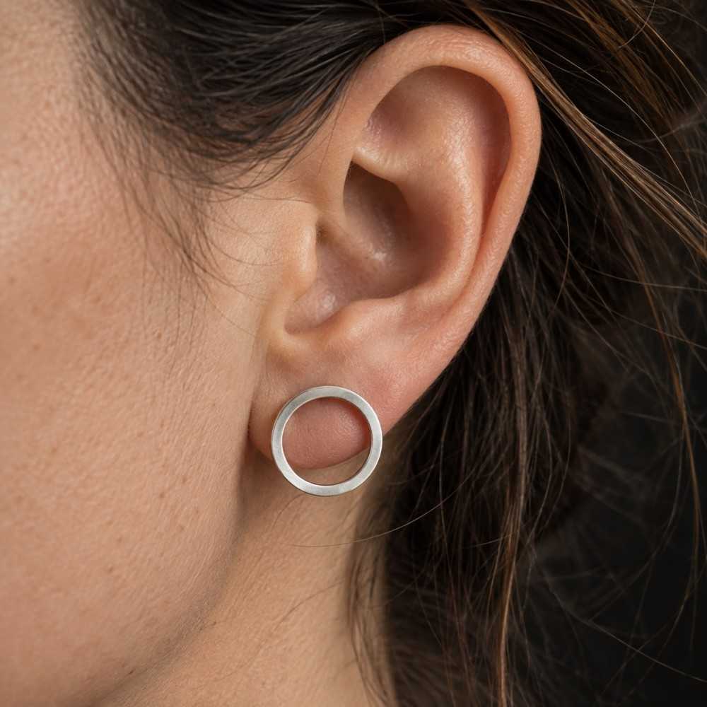 Petites puces d'oreilles en forme de cercle de style minimalsite en argent 925 fait main en Suisse romande. Bijoux à offrir.